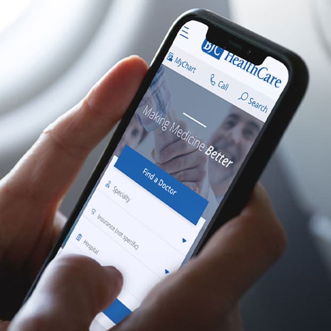 Hand holding an iPhone showing a healthcare site